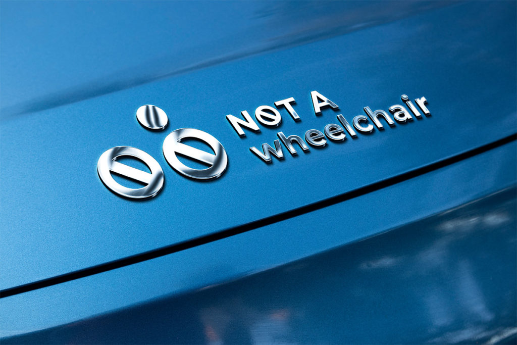 Metallic emboss of 'NOT A Wheelchair' logo on a blue metallic vehicle