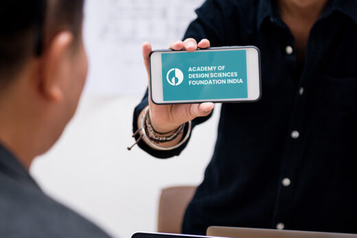 DESCIN logo on a mobile device and a laptop