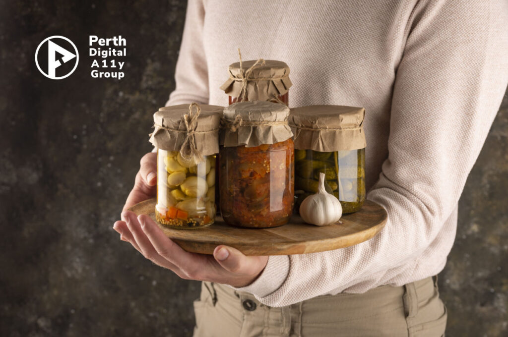 A person holding sealed bottles of pickles and spices